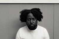 a black and white photo of a man with afro hair